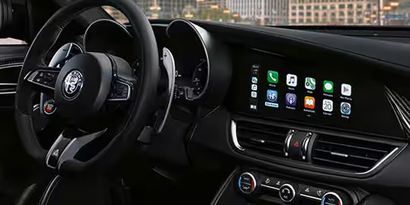 An Alfa Romeo Giulia interior featuring a digital display with Apple CarPlay