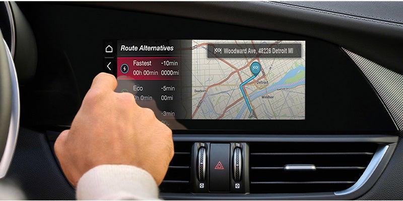 An Alfa Romeo Giulia dashboard showing a navigation map on the central screen