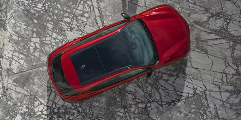 Top-down view of a red SUV parked on a cracked stone surface
