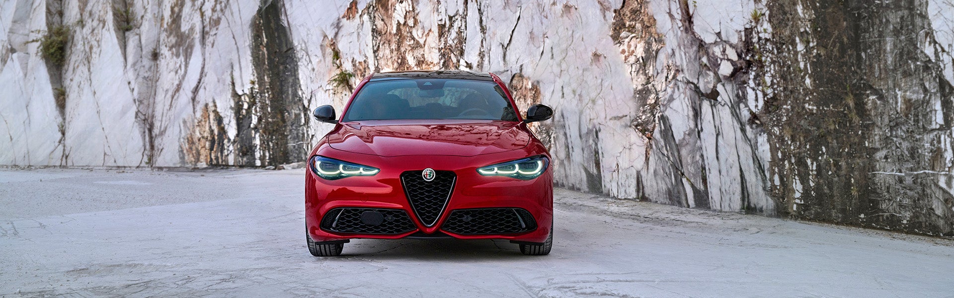 Front view of a red Alfa Romeo Giulia in a marble quarry