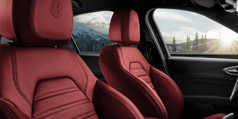 Red leather sport seats featuring an embossed Alfa Romeo headrest logo.