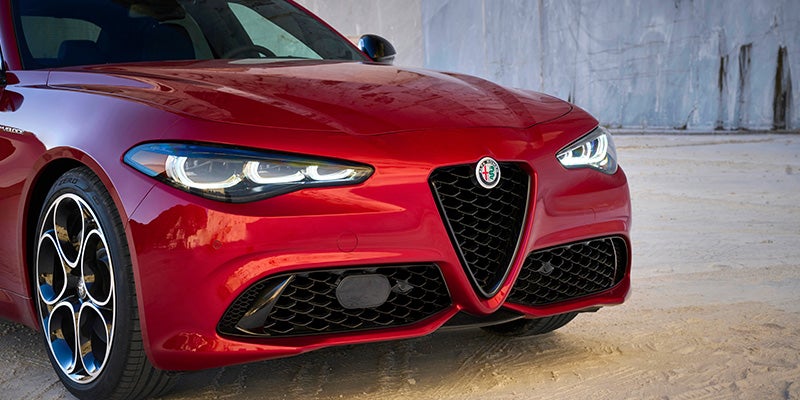 Red Alfa Romeo Giulia featuring signature trilobe grille and "3+3" LED headlights.
