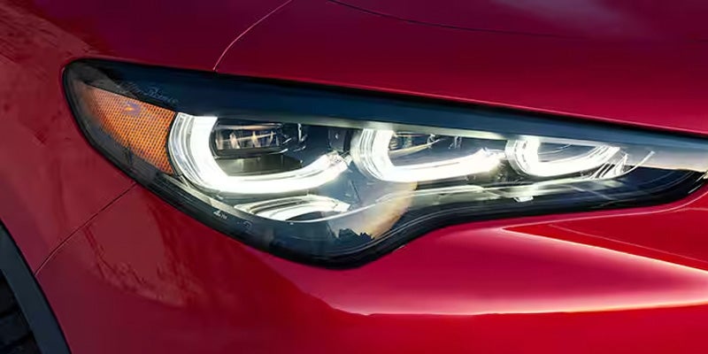 Close-up of the sleek LED headlight and front red bodywork