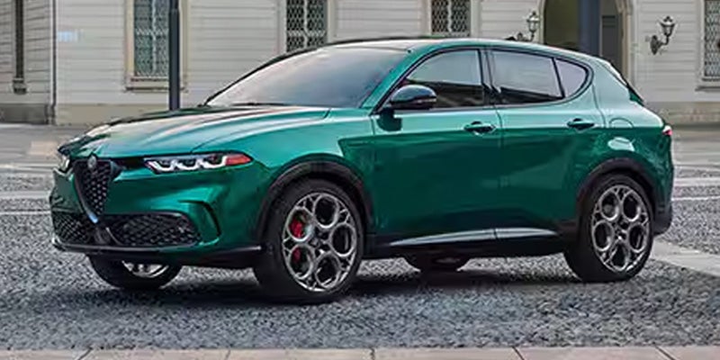 Side profile of a metallic green Alfa Romeo Tonale SUV parked.