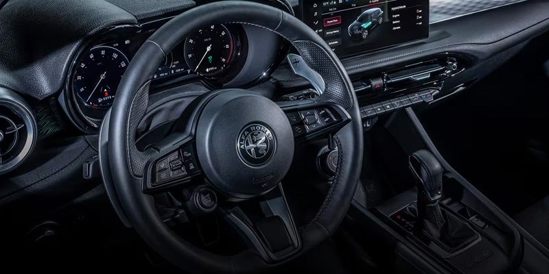 Modern interior of an Alfa Romeo Tonale featuring a leather steering wheel